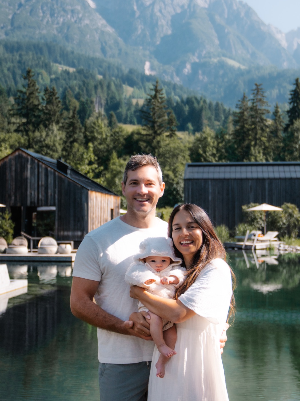 Catarina and Rafa holding their son Louie beside a mountain lake