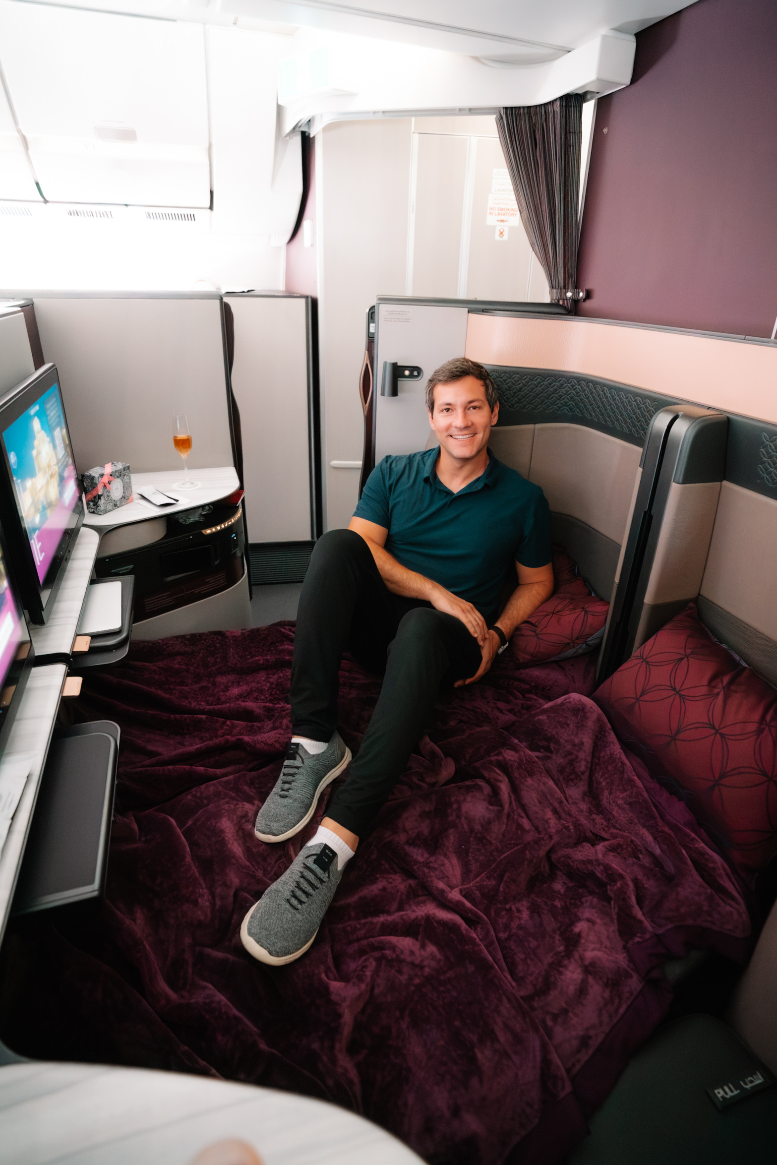 Rafa relaxing on a made-up bed in a Qatar Airways Qsuite