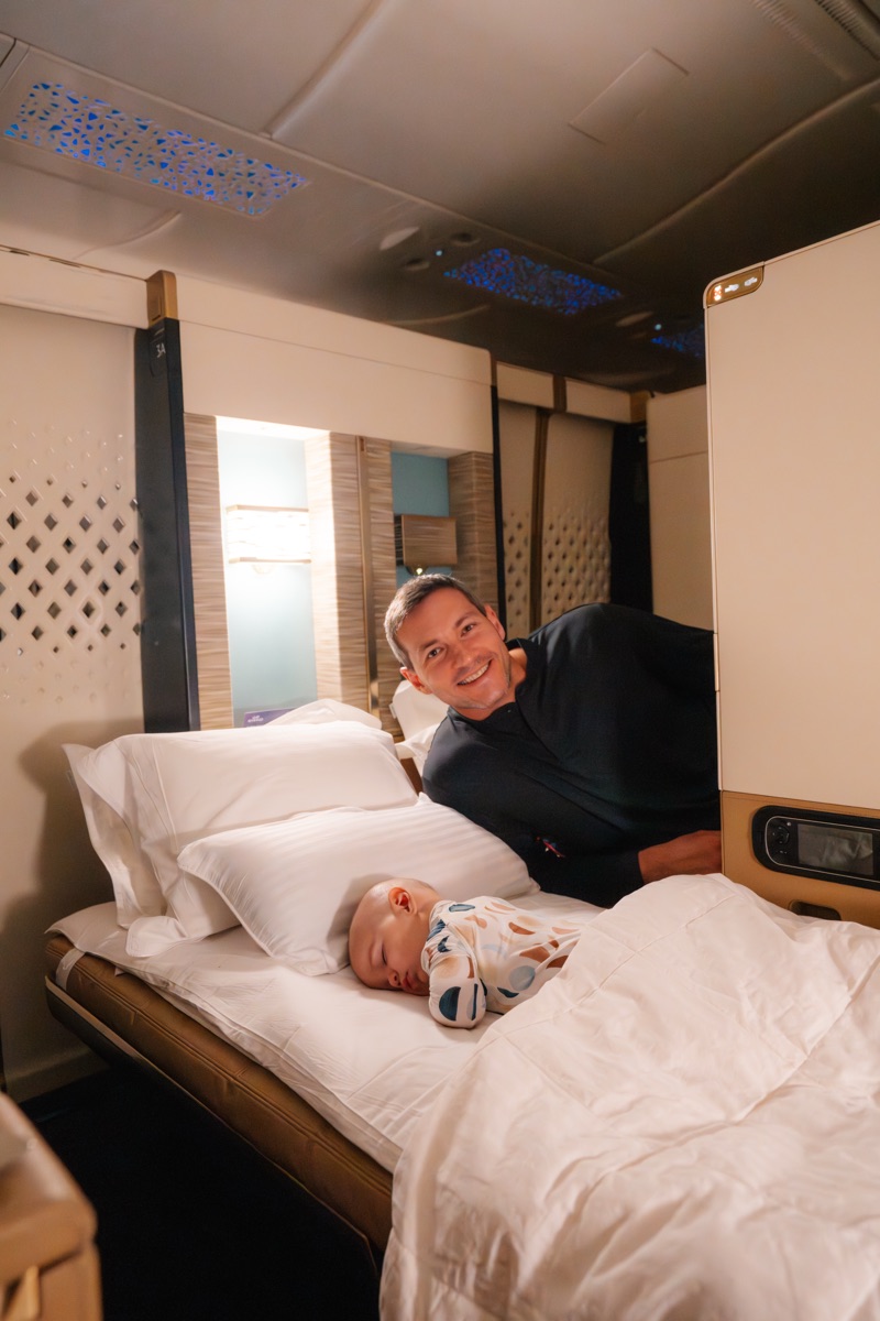 Rafa lying in an Etihad First Class bed with baby Louie
